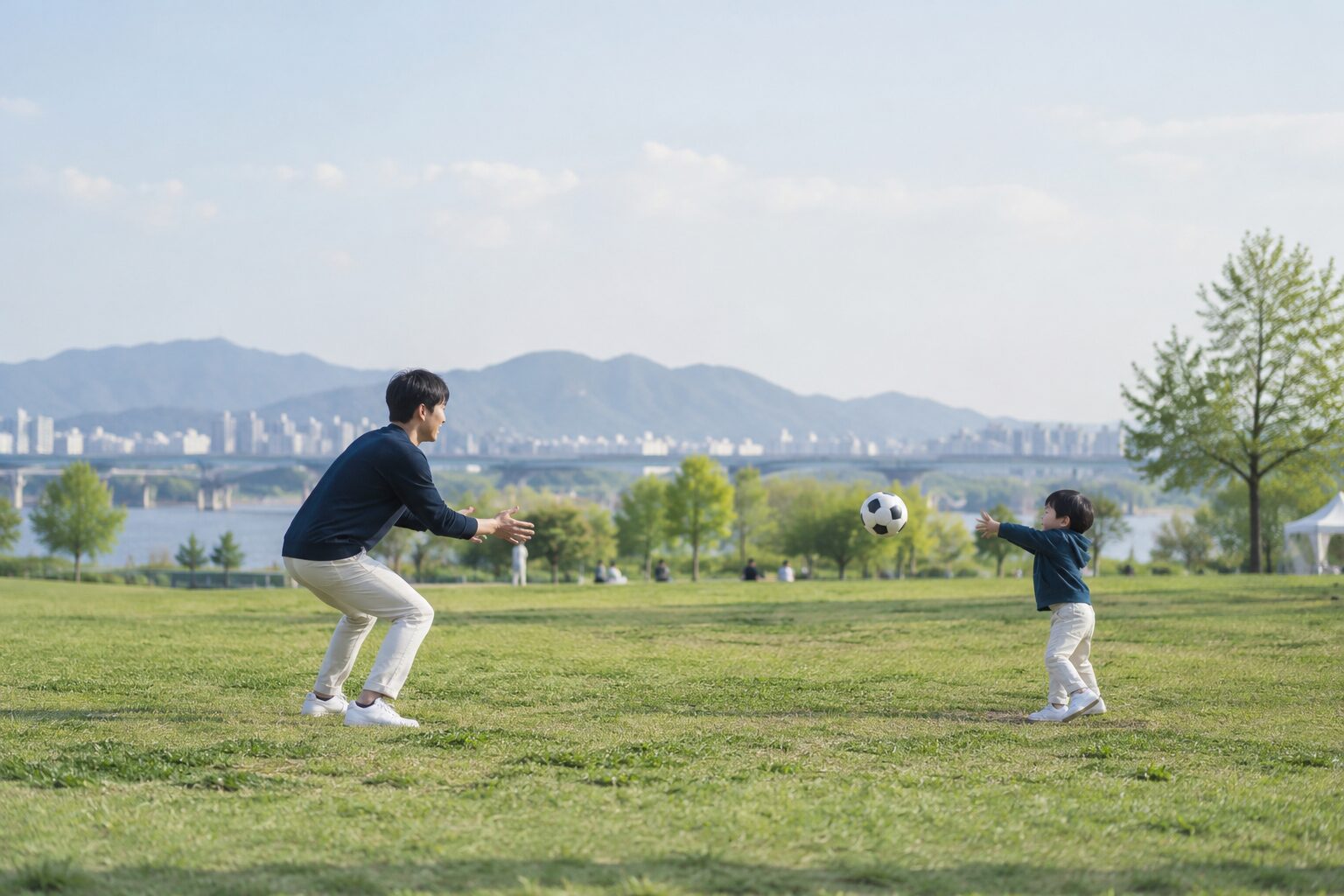 공원에서 공놀이를 하는 아빠와 아이